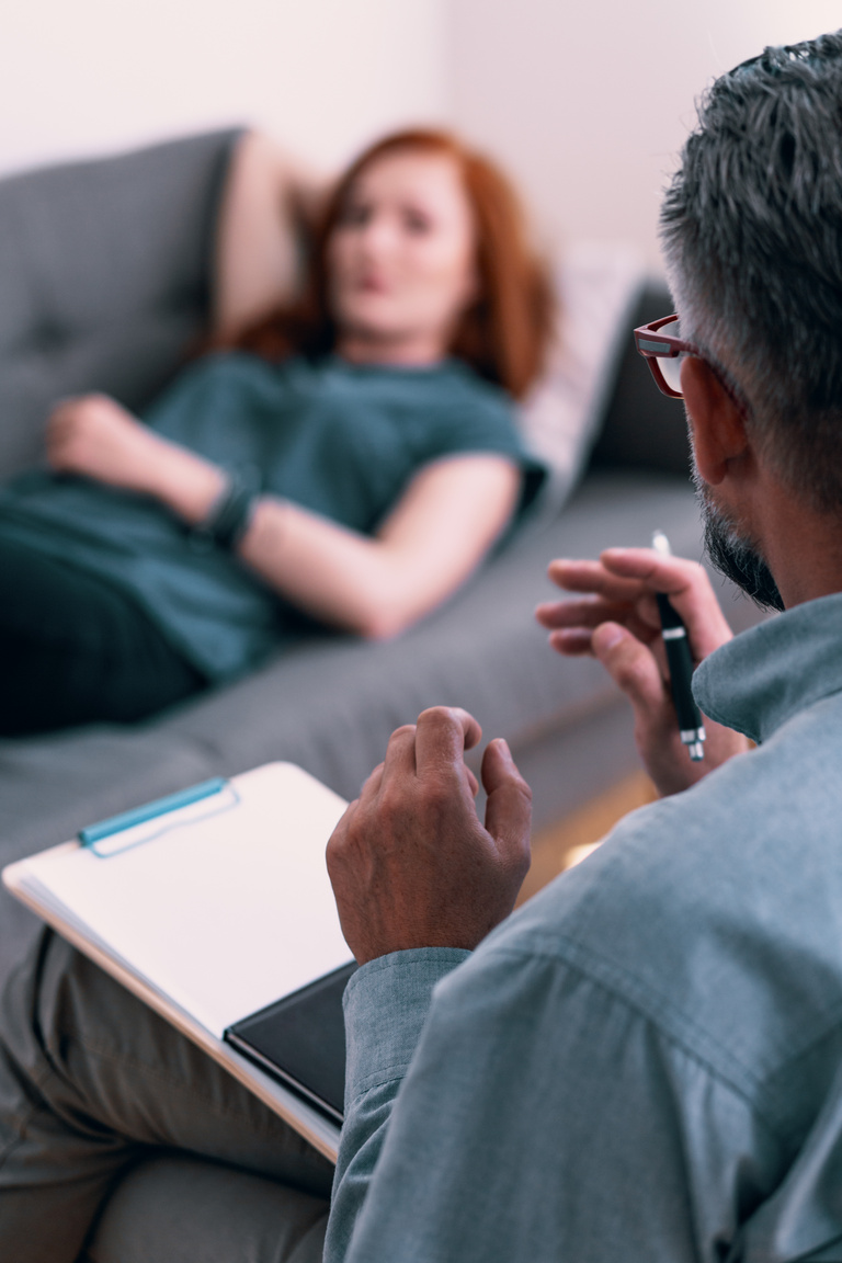 Psychotherapist with notes talking with client during therapy